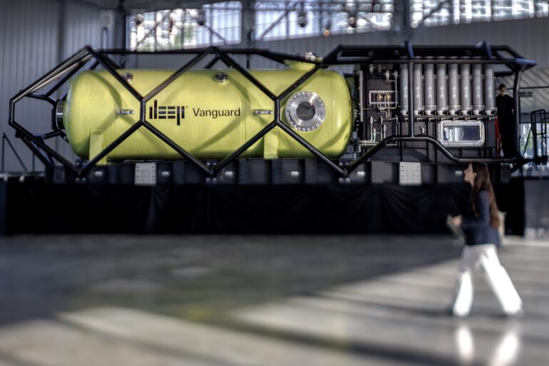 Una persona camina frente al hábitat submarino humano piloto Vanguard DEEP, exhibido en un almacén en Miami, Florida, Estados Unidos, el 29 de octubre de 2025.