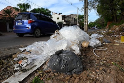 Montones de basura, incluyendo bolsas plásticas y cartones, en un área residencial de Asunción.