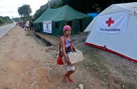 Una mujer lleva una caja de donaciones en un campamento de la Cruz Roja Cubana cerca del pueblo de San Antonio del Sur, provincia de Guantánamo, Cuba.