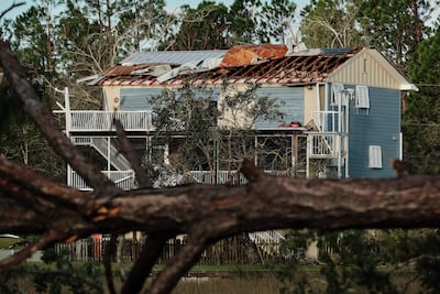 Un árbol caído yace frente a una vivienda que perdió el tejado tras tocar tierra el huracán Isaias en Milton, Florida (EE. UU.)