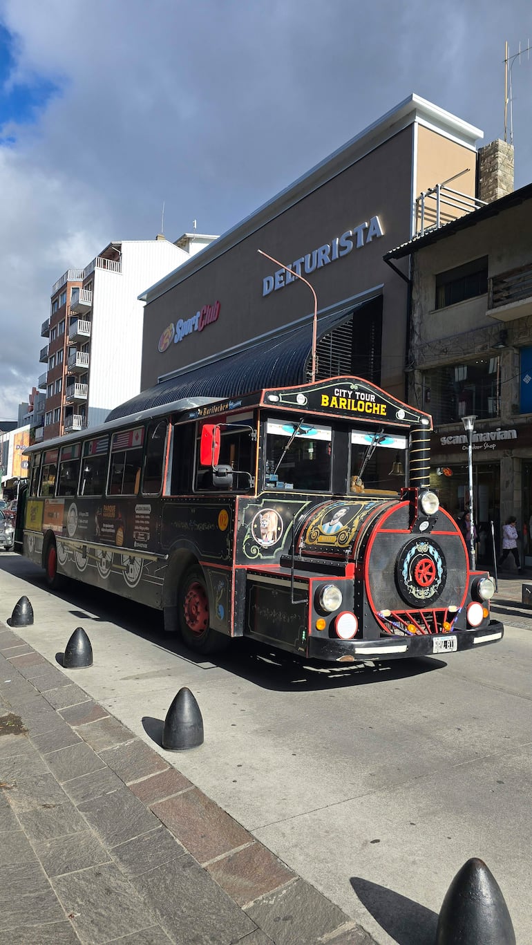 Autobús de Delturista con diseño vintage y decoraciones, estacionado frente a un edificio comercial en un día nublado.