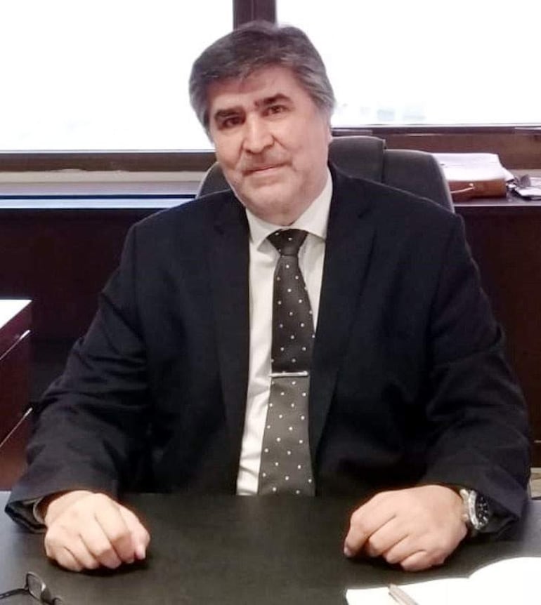 Juan Carlos Duarte, vestido con traje oscuro y corbata de puntos, muestra una expresión tranquila en su oficina.