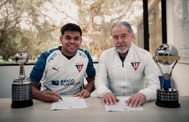 El extremo paraguayo, Rodney Redes en la firma de su vínculo junto al presidente de la Liga Deportiva Universitaria de Quito, Isaac Álvarez.