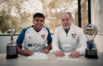 El extremo paraguayo, Rodney Redes en la firma de su vínculo junto al presidente de la Liga Deportiva Universitaria de Quito, Isaac Álvarez.