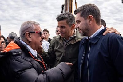 Santiago Peña con gafas de sol y chaqueta negra, Alliana en chaqueta gris clara, Fretes en chaqueta oscura, conversando en reunión al aire libre.