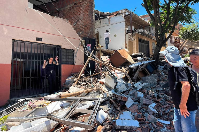 Personas observan los escombros en una calle tras un terremoto en Pereira, Colombia, el 10 de agosto de 2026. Un fuerte sismo sacudió Colombia y países vecinos de América Latina el 10 de agosto de 2026; equipos médicos acudieron rápidamente a asistir a las víctimas después de que varios edificios sufrieran daños o colapsaran en diversas ciudades. (Foto de Roberto Betancourt / AFP)