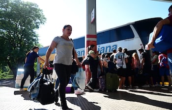 Pasajeros a punto de abordar un colectivo hacia el interior del país, para la Semana Santa.