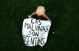 El futbolista argentino Giovani Lo Celso despliega una pancarta con la leyenda 'Las Mavinas son argentinas' tras la semifinal disputada ayer por Argentina e Inglaterra, en el Mundial 2026.