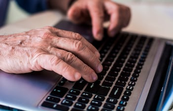 mano de un adulto mayor anciano tecleando en una computadora.