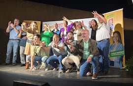 Soledad Núñez en evento político, rodeada de personas felices que levantan las manos y sostienen carteles de apoyo.