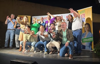 Soledad Núñez en evento político, rodeada de personas felices que levantan las manos y sostienen carteles de apoyo.