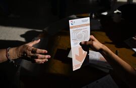 A woman casts her vote during presidential elections in Asuncion on April 30, 2023. - Paraguayans go to the polls to choose between right-wing economist Santiago Peña and center-left lawyer Efrain Alegre, both social conservatives, who face off in Paraguay's most closely-run presidential election in many years. (Photo by Luis ROBAYO / AFP)