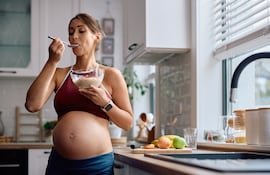 Mujer embarazada comiendo.