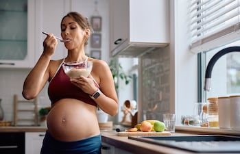 Mujer embarazada comiendo.