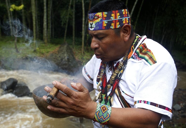 Jaibaná o médico tradicional José Arnulfo Vaguiaza, miembro de la comunidad Embera Chamí, mientras realiza un ritual de limpieza espiritual en el resguardo Karmata Rúa durante la ruta de turismo étnico en el municipio de Jardín, Antioquia (Colombia).