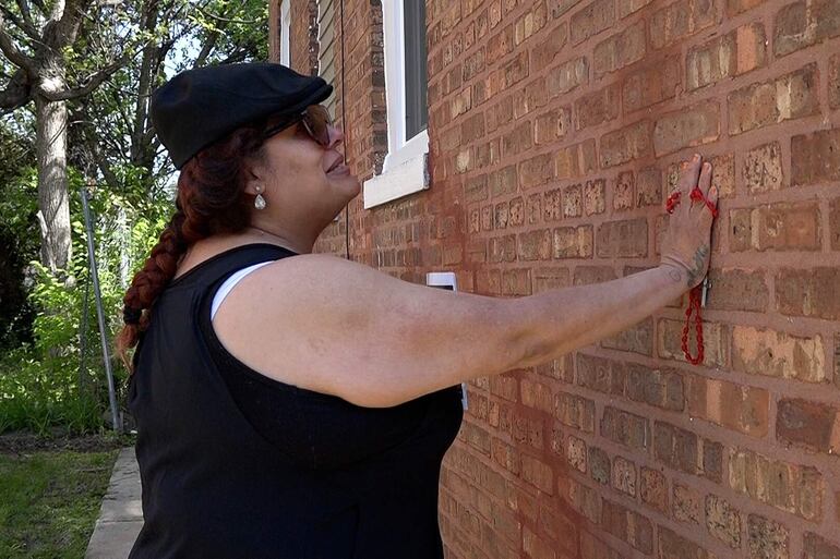 Captura de video que muestra a una mujer tocando una pared de la casa donde el papa León XIV pasó sus primeros años, este sábado en Chicago (Estados Unidos).