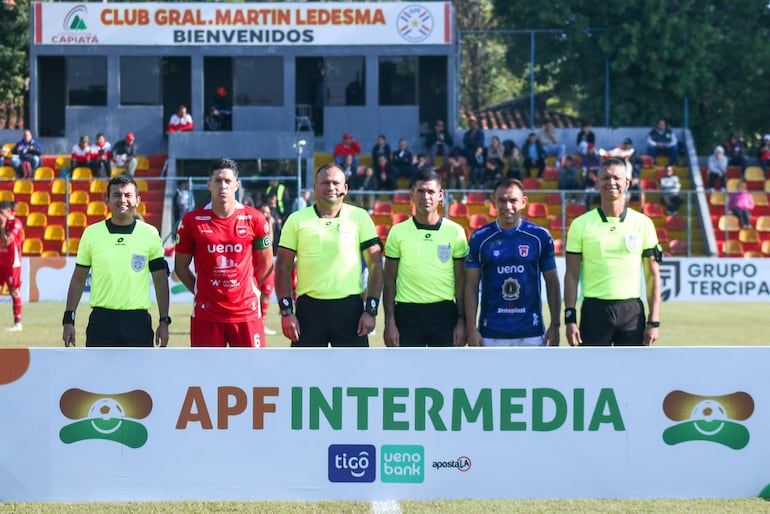 Los capitanes de ambos elencos posan con la terna arbitral antes del arranque del partido.