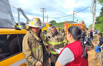 Una fiscalizadora del MTESS conversa con dos de los bomberos voluntarios.