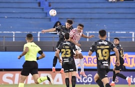 El zaguero de Olimpia, Juan Ángel Vera va a la disputa aérea con el delantero del Sportivo San Lorenzo, Cristhian Colmán.