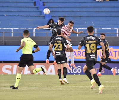El zaguero de Olimpia, Juan Ángel Vera va a la disputa aérea con el delantero del Sportivo San Lorenzo, Cristhian Colmán.