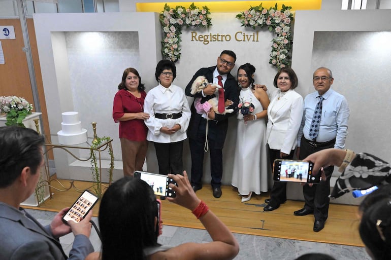 Andrés Alquinga y Diana Tupiza posan junto a su mascota Luna, testigo simbólico de su matrimonio, en la oficina del Registro Civil Central de Quito, el 7 de julio de 2026.