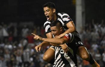 Lorenzo Melgarejo se trepa al goleador Óscar Cardozo, tras el segundo gol de Libertad frente a Luqueño.
