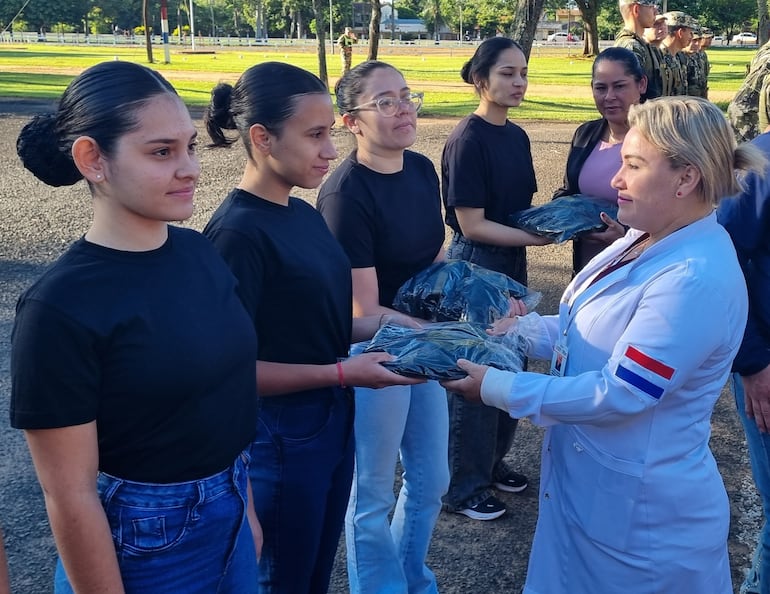 Madre de una de las cimeforistas realizando la entrega del uniforme a su hija.