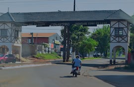 Arco de entrada a Obligado con letrero 'siéntase como en casa', en un entorno urbano y soleado.
