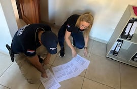 La fiscala Ruth Benítez verifica algunos de los documentos hallados en el estudio jurídico de Zully Ortiz.