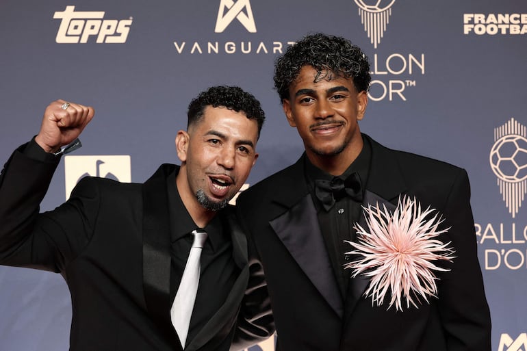 Lamine Yamal posa junto a su padre, Mounir Nasraoui, a su llegada para asistir a la ceremonia de entrega del Balón de Oro de France Football 2026 en el Palladium Theatre de Londres. (FRANCK FIFE / AFP)