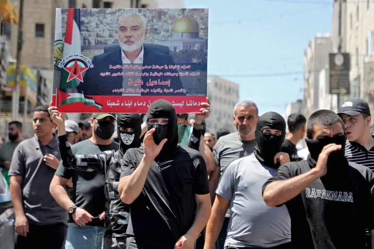 Hombres palestinos denuncian el asesinato de Haniyeh en una protesta en Hebrón el 31 de Julio de 2024.