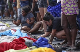 Una mujer llora frente a cuerpos en una calle este miércoles, en Río de Janeiro (Brasil). La operación policial lanzada el martes en Río de Janeiro, la más letal de la historia de la ciudad brasileña, dejó 132 muertos, entre ellos cuatro agentes, según la Defensoría Pública regional.