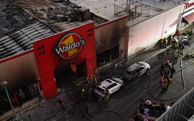 Bomberos controlando un incendio en una tienda comercial este sábado, en la ciudad de Hermosillo en Sonora (México).
