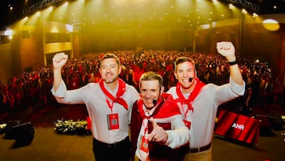 Santiago Peña y Pedro Alliana en camisas blancas y pañuelos rojos, levantando los brazos en un evento con multitud de personas vistiendo rojo.