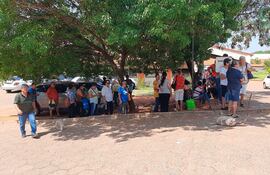 Pacientes del Hospital de Clínicas se ubican bajo los árboles mientras esperan en la fila para sacar turno para oftalmología.