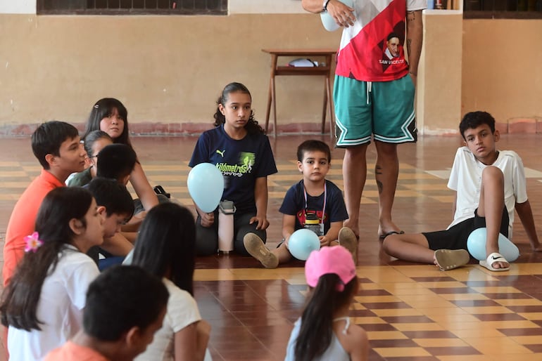 Niños con globos celestes en uno de los juegos de la Pascua Infantil en San Vicente de Paul.