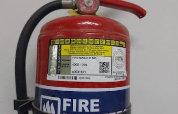 Extintor de incendios rojo con etiqueta amarilla de verificación, fondo blanco sin personas visibles.