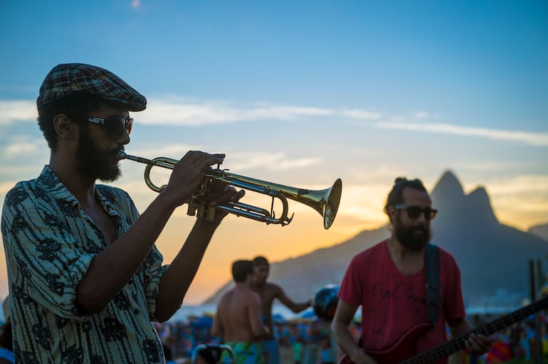 Músicos brasileños en una actuación informal sobre el paseo marítimo de la playa de Ipanema, mientras el sol se pone en Arpoador, el popular mirador.
