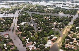 Vista aérea de Cerrito, con casas y calles parcialmente sumergidas en agua rodeadas de densa vegetación.