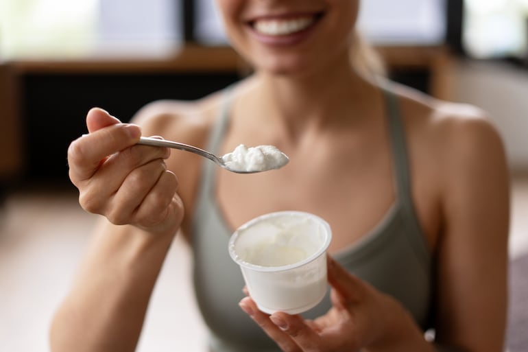 Mujer consume yogur.