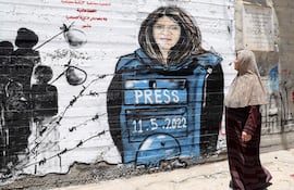 -FOTODELDÍA- BELÉN, 16/05/2022.- Una mujer pasa junto a un mural dedicado a la periodista palestina de Al Jazeera Shireen Abu Akleh en Belén. EFE/ABED AL HASHLAMOUN