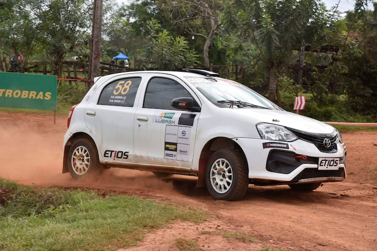Toyota Etios número 58 en movimiento sobre un camino de tierra, rodeado de vegetación y polvo en el aire.