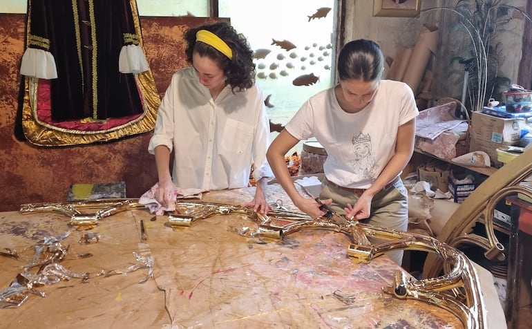 Almudena y Macarena Ruiz preparan el retablo donde serán montados los cuadros vivientes durante el Viernes Santo.