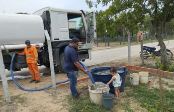 Desde un camión cisterna descargan el agua cruda tomada del río Paraguay para las familias de Carmelo Peralta, donde no logran solucionar la falta de sistema de suministro de agua potable.