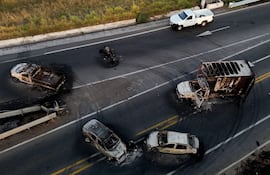 Esta vista aérea muestra autos y camionetas quemadas, aparentemente incendiadas por grupos del crimen organizado en respuesta a un operativo para detener a un objetivo de seguridad prioritario, en una carretera cerca de Acatlán de Juárez, Jalisco, México.