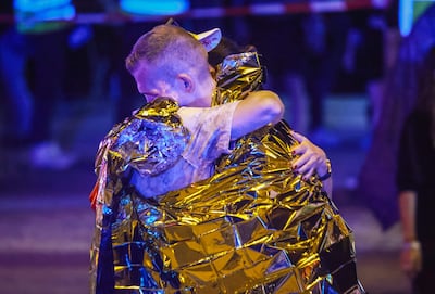 Dos personas se abrazan cerca del sitio del atropello en Berlín.