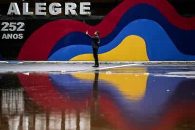 Fotografía de un hombre en la región central e histórica de la ciudad durante una inundación en Porto Alegre (Brasil). La Conmebol postergó los partidos de Gremio e Internacional por Libertadores y Sudamericana, respectivamente.