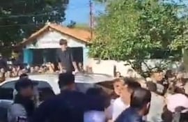 Policías toman del cuello a un hombre en medio de una gresca, en Alberdi, frente a un local de votación.