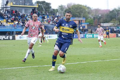 Santiago Salcedo, autor del gol del 12 de Junio de Villa Hayes, de penal, se dispone a controlar el balón ante la llegada del también experimentado Teodoro Paredes.