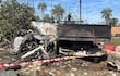 Restos de un camión calcinado en un terreno abierto, rodeado de cintas de seguridad y humo residual.